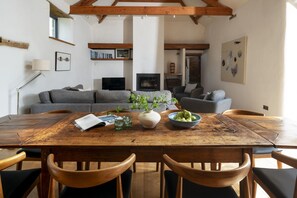 A dining area with a wooden table, chairs, and a vase with green pears. - Avallen Barn - sleeps 8 guests  in 4 bedrooms (Helford)