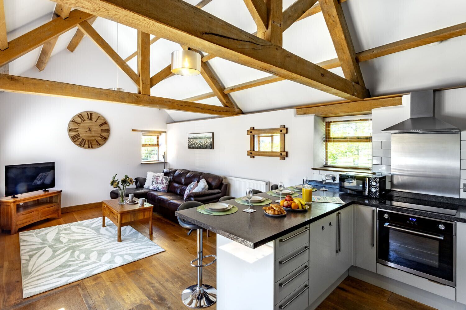 A modern kitchen with a central island, built-in appliances, and a dining area with a sofa and coffee table.