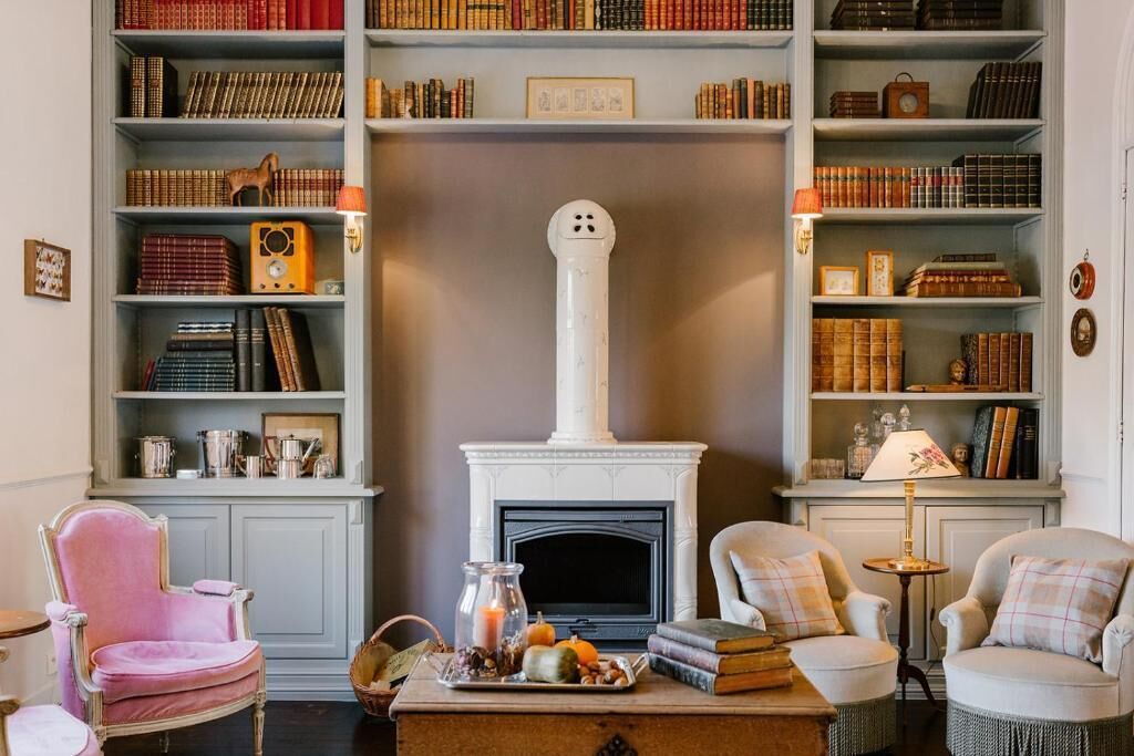 Una sala de estar acogedora con chimenea, estanterías y asientos cómodos.