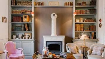 Una sala de estar acogedora con chimenea, estanterías y asientos cómodos.