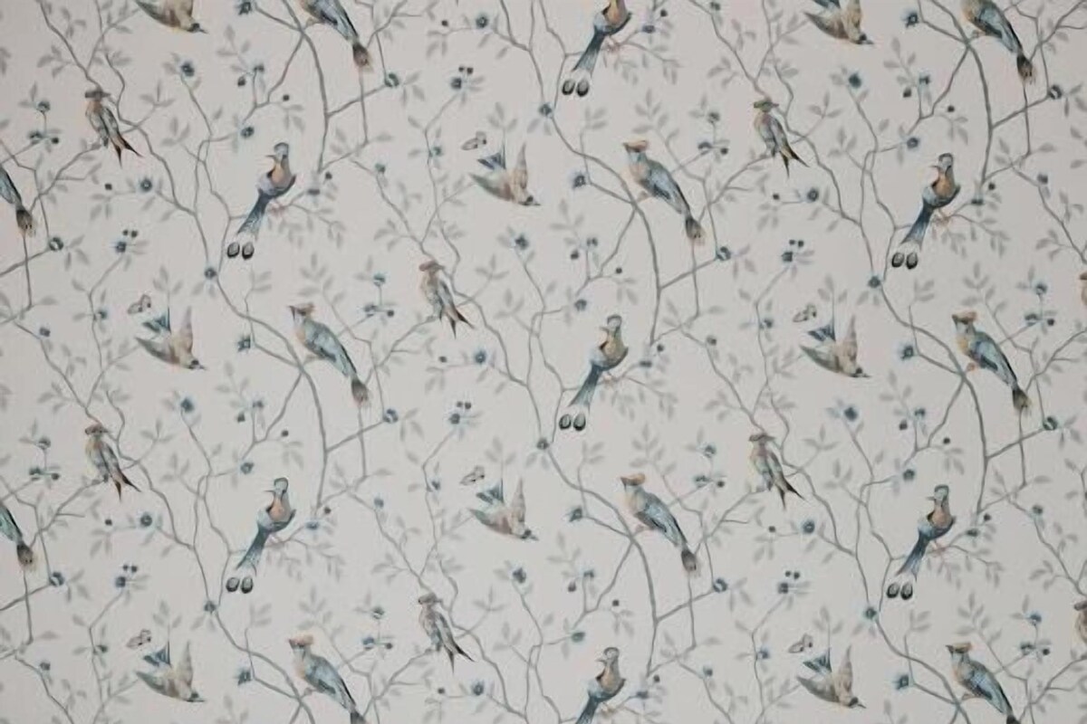 A bed with white bedding and a headboard against a wall with a floral wallpaper pattern.