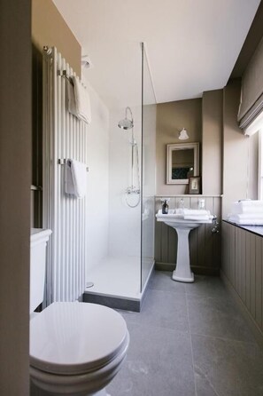 A bathroom with a toilet, shower, and sink. - La Maison d'Hôtes (SILLY)