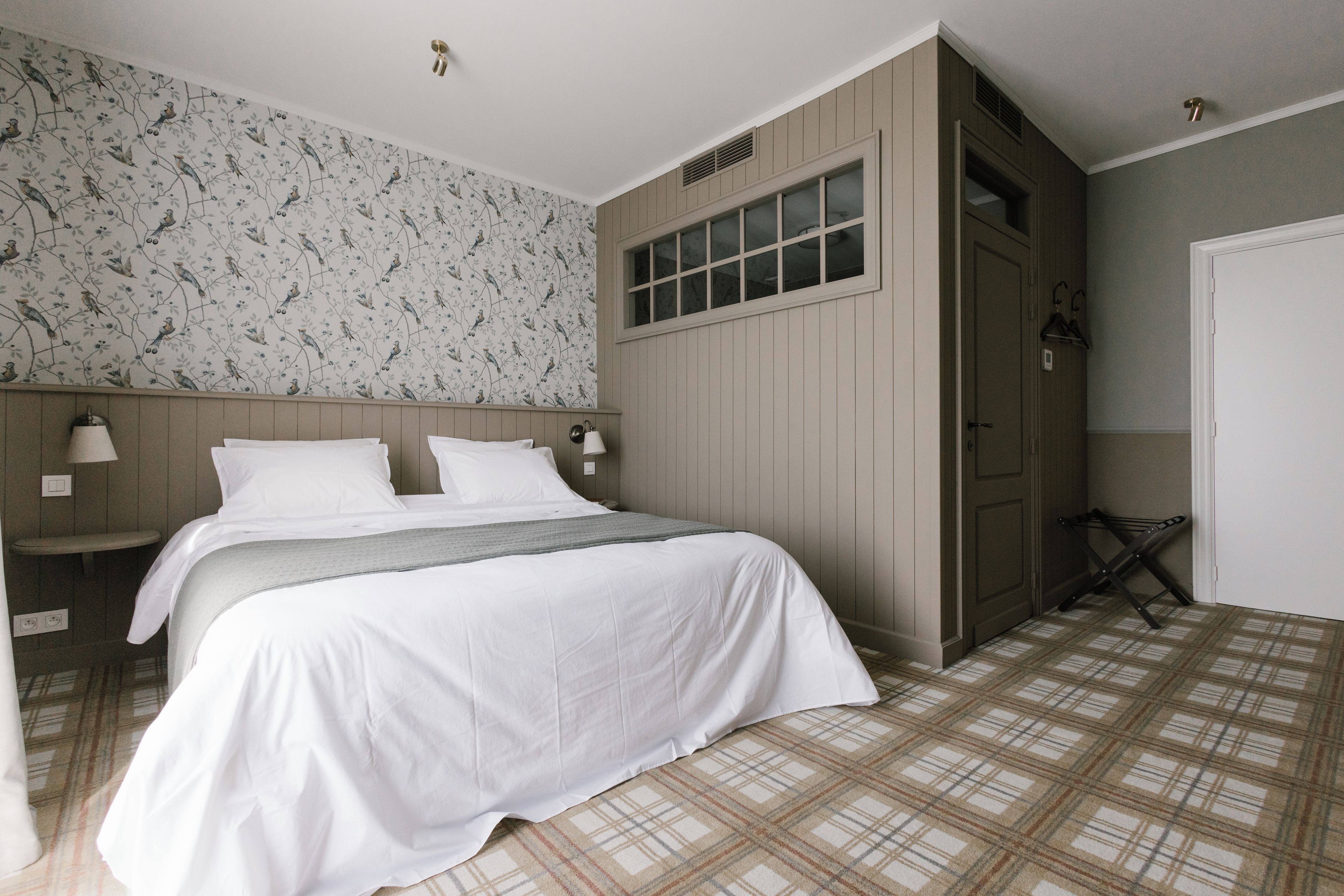Une chambre à coucher avec un lit, une table de chevet, une fenêtre et une porte.