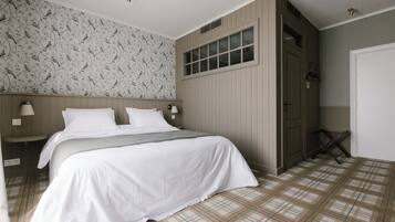 Une chambre à coucher avec un lit, une table de chevet, une fenêtre et une porte.