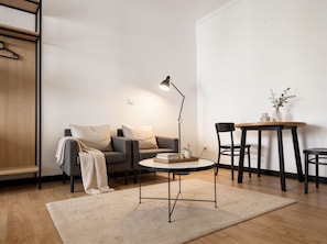 A modern living room with a sofa, a coffee table, and a dining table. - Old Town Heart XXXVI - National Stadium Tower 11 (Warsaw)