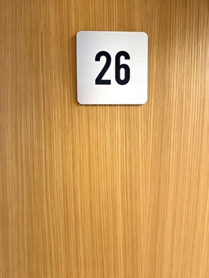 A white sign with the number 26 on a wooden surface. - Old Town Heart – National Stadium Tower 26 (Warsaw)