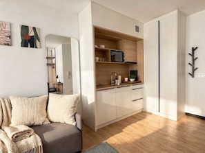 A compact living space with a kitchenette, a sofa, and a dining area. - Old Town Heart - National Stadium Tower 87 (Warsaw)