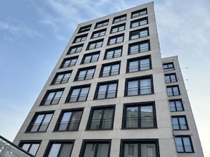 A multi-story building with a modern architectural design, featuring a series of balconies and large windows. - Old Town Heart - National Stadium Tower 87 (Warsaw)