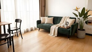 A living room with a green sofa, a coffee table, and a potted plant. - Old Town Heart - National Stadium Tower 47 (Warsaw)