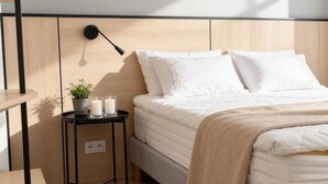 A bedroom with a bed, bedside table, lamp, and a small potted plant. - Old Town Heart - National Stadium Tower 47 (Warsaw)
