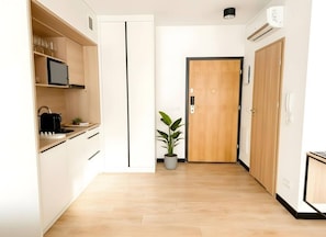 A modern kitchen with a microwave, kettle, and potted plant. - Old Town Heart - National Stadium Tower 47 (Warsaw)