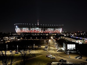 A stadium with a large, illuminated structure at night. - Old Town Heart-National Stadium Tower 12 (Warsaw)
