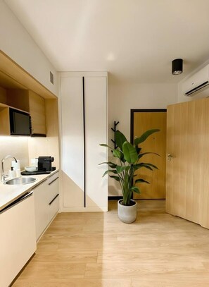 A modern kitchen with a microwave, sink, and a potted plant. - Old Town Heart - National Stadium Tower 17 (Warsaw)