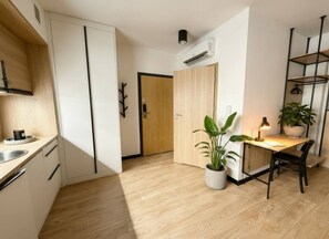 Eine moderne Küche mit Einbauherd, einem Essbereich mit Tisch und Stühlen sowie einem Blumentopf.