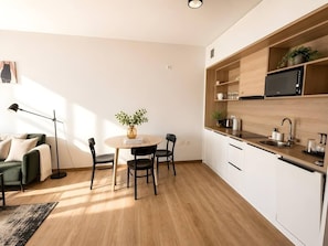 Eine moderne Küche mit weißen Schränken, einer Holz Arbeitsplatte und einer eingebauten Mikrowelle.