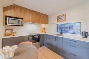 A modern kitchen with a microwave, oven, and sink. - Modern 1BR Near Christchurch CBD & Cashel Street (Christchurch)