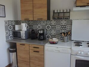 A kitchen with a microwave, coffee maker, toaster, and a dishwasher.
