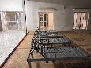Una habitación con varias zonas de estar, suelo de baldosas y vistas a través de un ventanal.