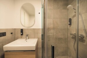 A modern bathroom with a glass-enclosed shower, a white sink, and a large mirror. - Kiez Mezzanine Studio for 4 in Berlin Neukölln (Berlin)