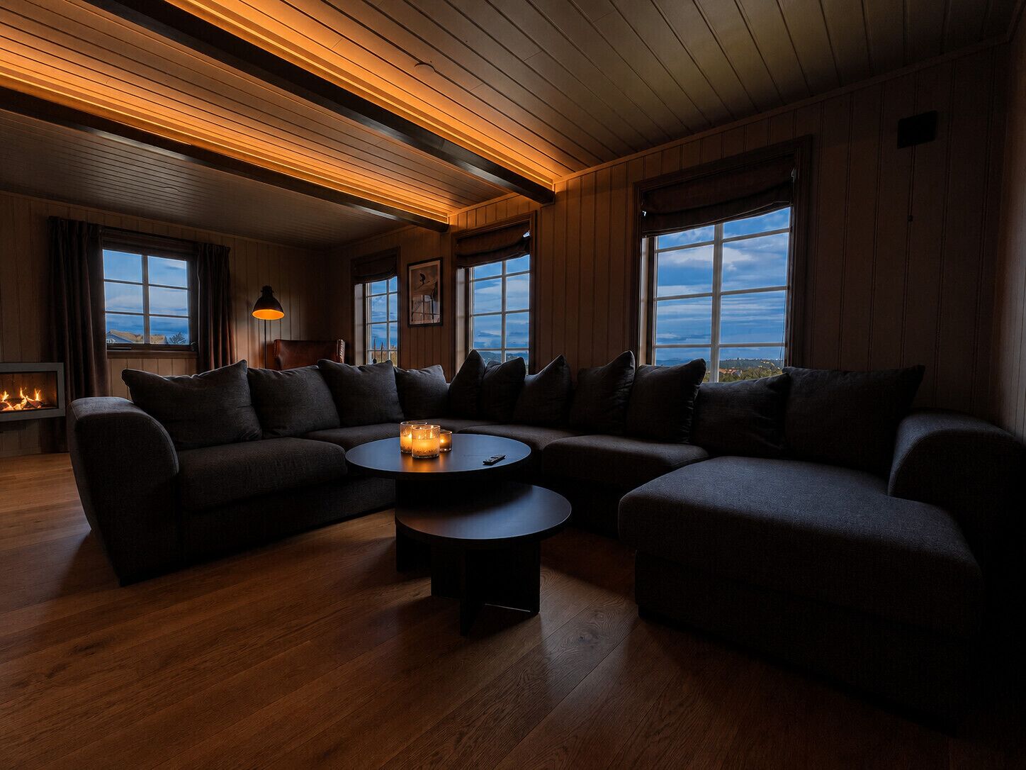 A cozy living room with a sectional sofa, a round coffee table, and a fireplace.