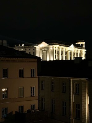A large, illuminated building with classical architecture, likely a hotel, with multiple windows and a prominent entrance. - Old Town Heart XXI- Pl.Teatralny (Warsaw)