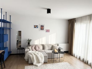 Ein modernes Wohnzimmer mit einer Couch, einem Couchtisch und einer blauen Regaleinheit.
