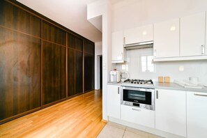 A modern kitchen with white cabinetry, a Bosch oven, and a wooden floor. - Old Town Heart V - Old Town Square (Warsaw)