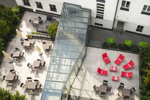 Eine Dachterrasse mit Außenbestuhlung und einer Glaskonstruktion.