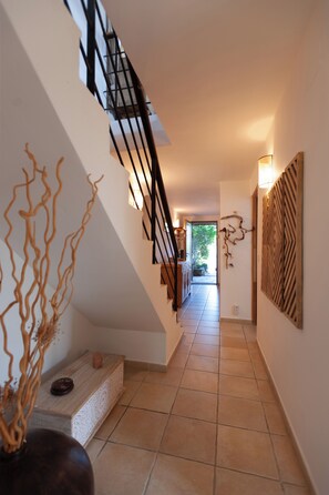A staircase with a modern design, leading to a room with a view of greenery outside. - Stunning stone sheep barn, infinity pool (Lecci)