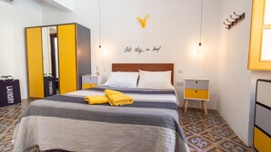 A hotel room with a bed, a wardrobe, a nightstand, and a wall decoration. - Stylish traditional house with sun terrace TELL1-1 (Birgu)