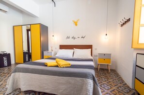 Ein Hotelzimmer mit Bett, Schrank, Nachttisch und Wandbild.