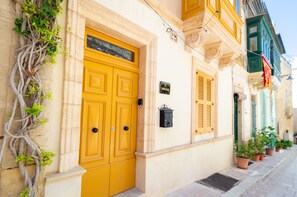 A building with a yellow door, a black mailbox, and a sign reading '18 Mustard'. - Stylish traditional house with sun terrace TELL1-1 (Birgu)