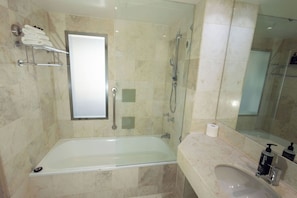 Ein modernes Badezimmer mit einer Duschkabine, einer Badewanne, einem Waschtisch und einem Spiegel.