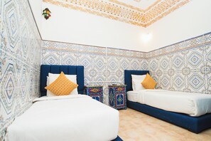 Quarto com duas camas, paredes estampadas e teto decorativo.