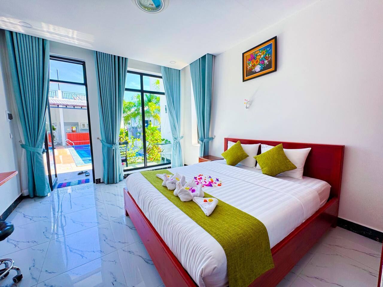 A hotel room with a bed, a window with curtains, a painting on the wall, and a view of the outside.