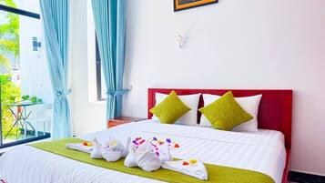 A hotel room with a bed, a window with curtains, a bedside table, and a wall-mounted picture.