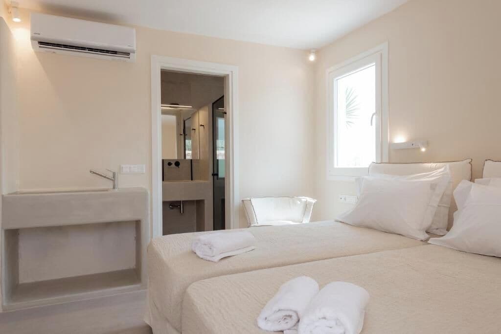 Una habitación de hotel con cama, baño y ventana.