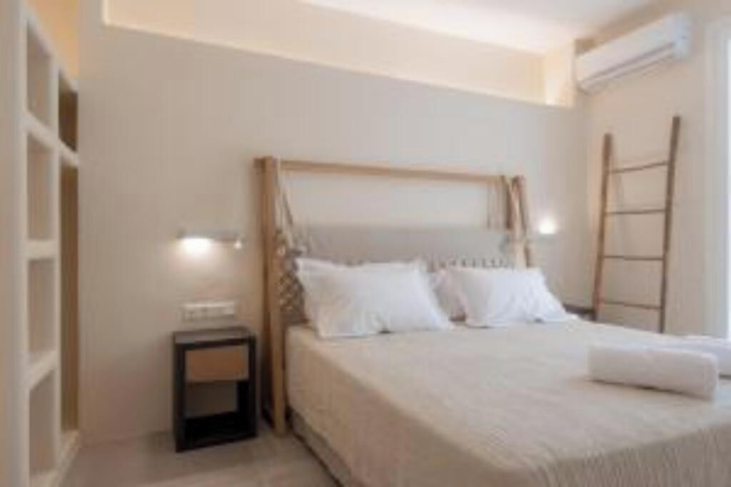 A bedroom with a bed, bedside table, and a ladder against the wall.