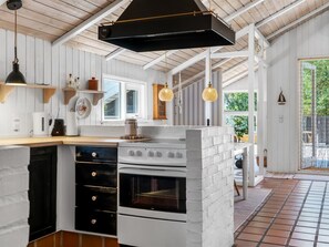 A kitchen with white cabinetry, a built-in oven, and a hanging light fixture. - "Florida" -  from the sea by Interhome (Hals)