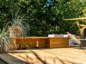 A wooden deck with a built-in bench and a large potted plant. - "Florida" -  from the sea by Interhome (Hals)