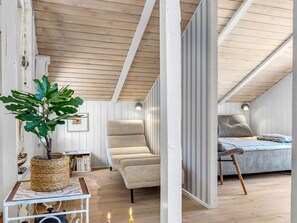 A cozy room with a bed, a chair, a table with a plant, and a bookshelf. - "Florida" -  from the sea by Interhome (Hals)