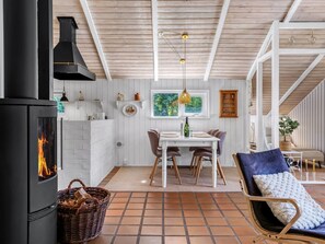 A cozy kitchen with a fireplace, dining area, and a comfortable seating space. - "Florida" -  from the sea by Interhome (Hals)