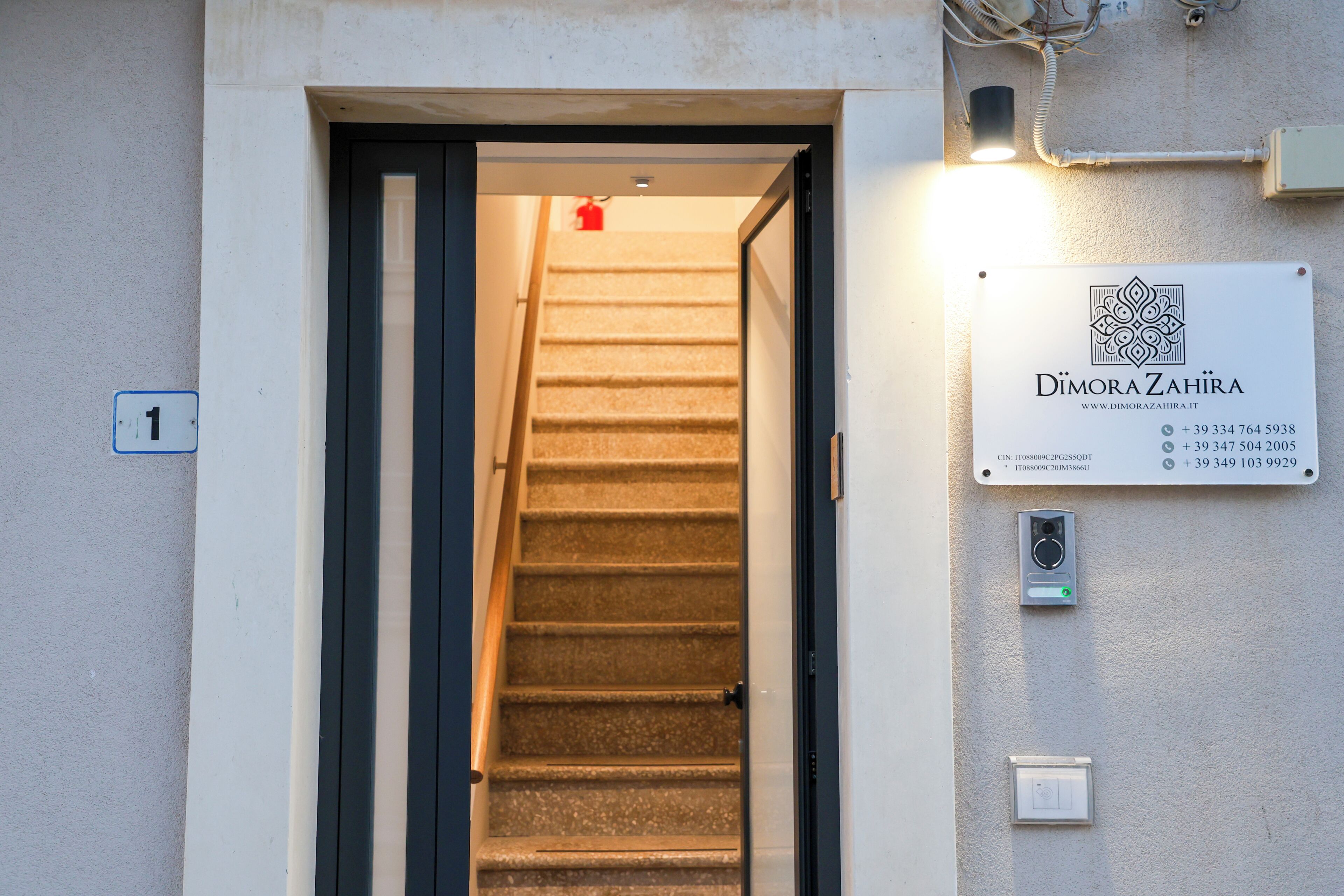 A staircase leading to a door with a sign above it.