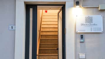 A staircase leading to a door with a sign above it.
