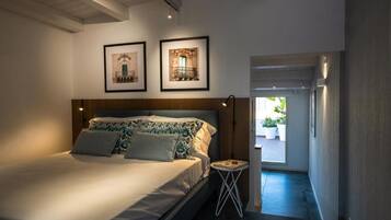 A bedroom with a bed, a nightstand, and two framed pictures on the wall.