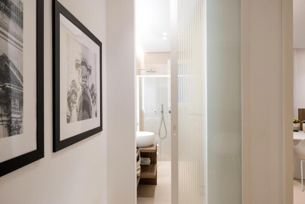 Ein modernes Badezimmer mit Dusche, Toilette und Waschbecken. An den Wänden hängen Bilder in Rahmen.
