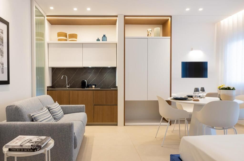 A modern, compact living space with a kitchenette, a dining area, and a seating area.