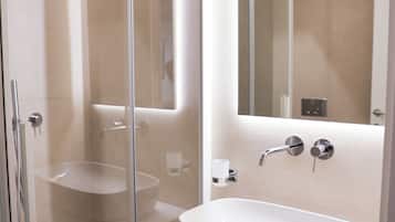 Une salle de bain moderne avec une douche à parois de verre, un lavabo blanc et un miroir.
