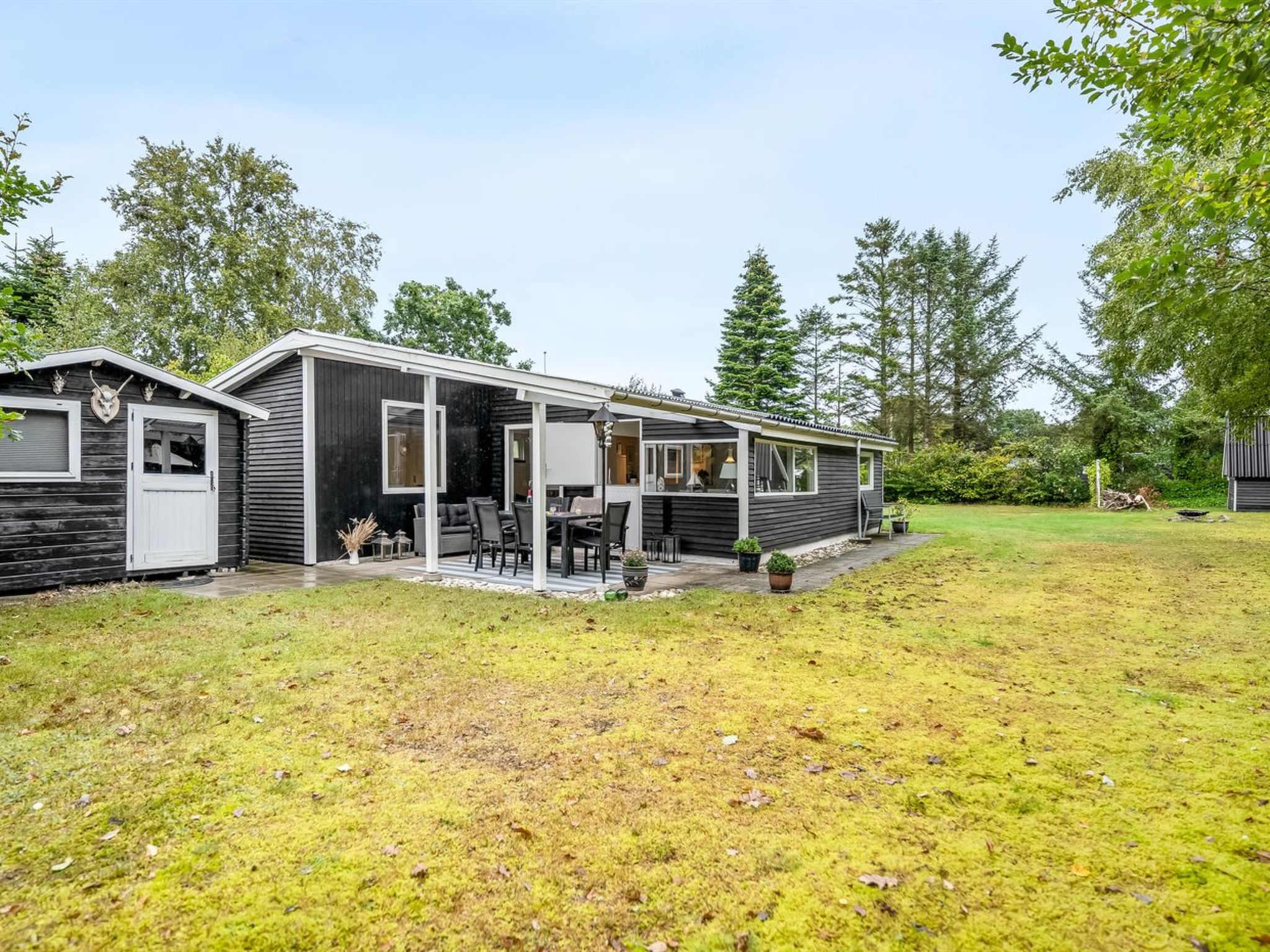 Une maison mobile dotée d’un patio, d’un garage et d’une petite terrasse.