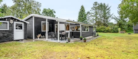 Una casa móvil con un patio, un garaje y una pequeña terraza.